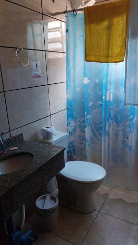 a bathroom with a toilet and a sink and a shower at Chácara Santa Rita de Cássia in Descalvado