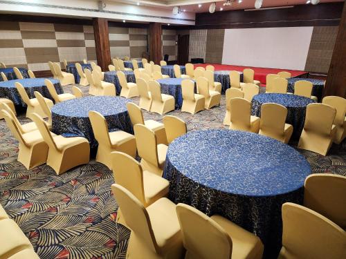 a conference room with blue tables and chairs at Dimora Hotel Thiruvananthapuram in Trivandrum