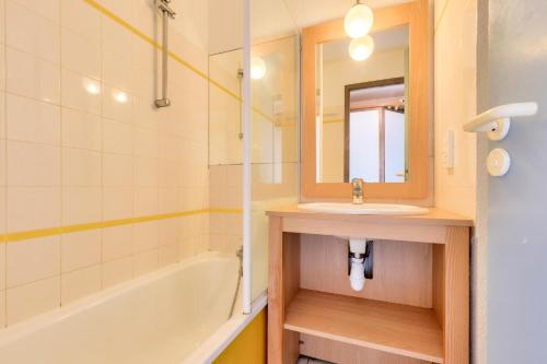 une salle de bain avec un lavabo, une baignoire et un miroir dans l'établissement Résidence Port Bourgenay - maeva Home - Studio 5 personnes - Sélection MAE-7944, à Talmont-Saint-Hilaire