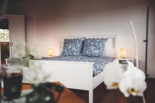 a white bed with blue pillows in a bedroom at Kinsau Rooms in Kinsau