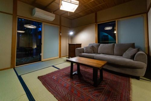 a living room with a couch and a coffee table at Ryokan Fukinoya in Yufuin