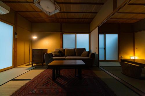 a living room with a couch and a table at Ryokan Fukinoya in Yufuin