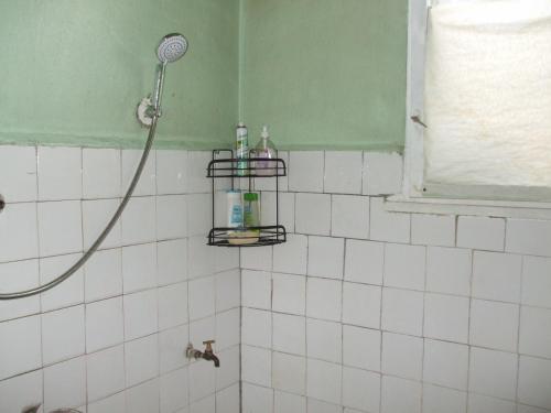 トゥルゴヴィシテにあるDaneto Apartmentの白いタイル張りの壁、シャワー付きのバスルーム