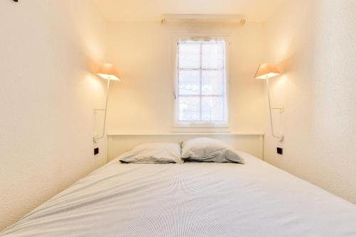 - une chambre avec un lit avec deux oreillers et une fenêtre dans l'établissement Résidence Port Bourgenay - maeva Home - Appartement 2 pièces 4 personnes - Sélection MAE-7684, à Talmont-Saint-Hilaire