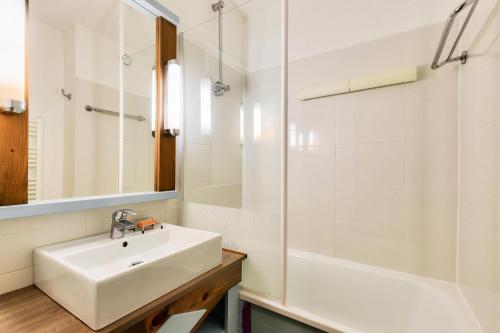 une salle de bain blanche avec un lavabo et une douche dans l'établissement Résidence Port Bourgenay - maeva Home - Appartement 2 pièces 4 personnes - Sélection MAE-7684, à Talmont-Saint-Hilaire