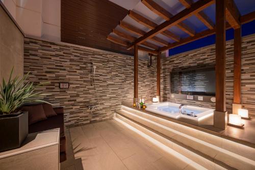a bathroom with a jacuzzi tub in a brick wall at コスタリゾート茅ヶ崎大人専用 in Suka