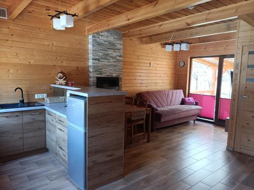 a kitchen and living room in a log cabin at Domki Bursztyn in Święta Katarzyna