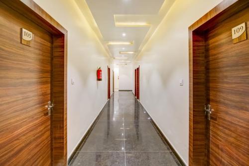 korytarzem z drewnianymi drzwiami w budynku w obiekcie OYO Hotel Paris Inn w mieście Hisār