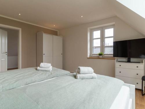 a large bedroom with two beds with towels on them at Doppelhaushälfte in Karolinenkoog in Karolinenkoog