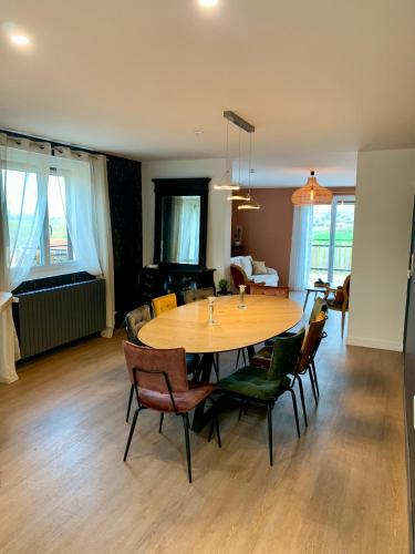 - une table à manger et des chaises dans le salon dans l'établissement Le Spanorama; gîte premium, à Vincelles