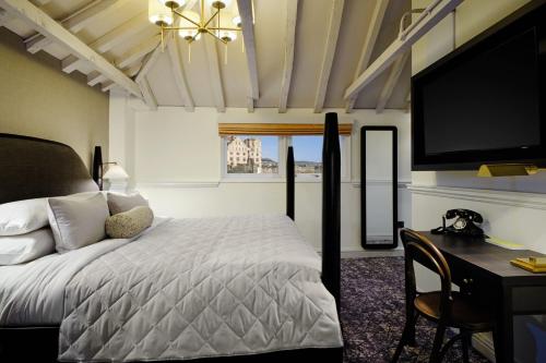 a bedroom with a bed and a desk and a tv at Abbey Hotel Bath, a Tribute Portfolio Hotel in Bath