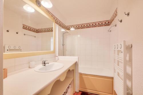 une salle de bain avec un lavabo, une baignoire et un miroir dans l'établissement Les Issambres Lauriers - maeva Home - Appartement 2 pièces 4 personnes - Prestige MAE-8981, aux Issambres