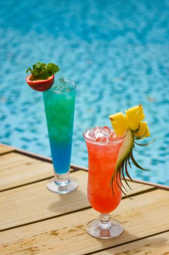 two cocktails sitting on a table next to a pool at Holiday Inn Express Phuket Patong Beach Central by IHG in Patong Beach