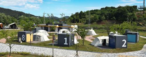 a group of tents in a park with trees at Starium Seocheon in Seocheon