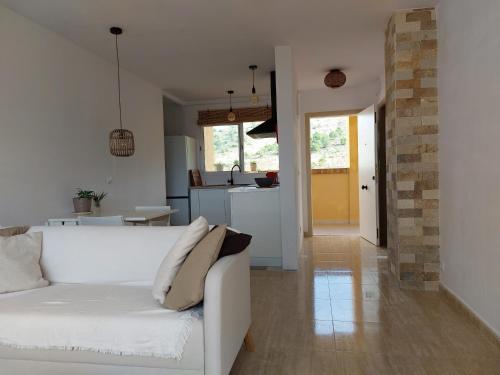 een woonkamer met een witte bank en een keuken bij Rincon de Loix Benidorm in Benidorm