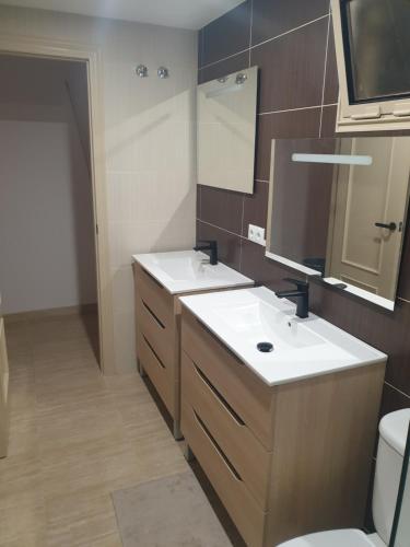 een badkamer met 2 wastafels en een toilet bij Rincon de Loix Benidorm in Benidorm