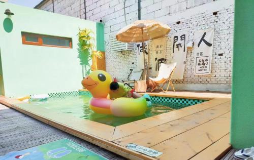 un pequeño pato de goma en una piscina con sombrilla en Relax Homestay at the foot of the Great Wall, en Huairou