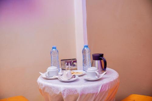 a table with a white table cloth and two bottles at Twin towers hotel in Kampala