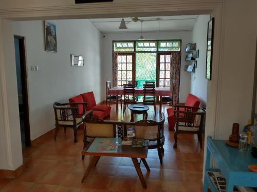 uma sala de jantar com mesas e cadeiras num quarto em Lady Gordons Homestay em Kandy