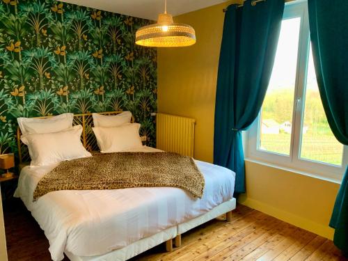 a bedroom with a bed with a floral wall at Le Spanorama; gîte premium in Vincelles