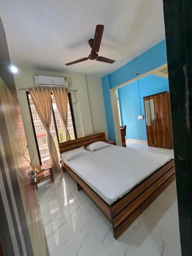 La Residence في نافي مومباي: غرفة نوم بسرير ومروحة سقف