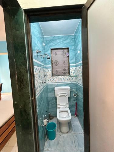 a bathroom with a toilet in a glass door at La Residence in Navi Mumbai