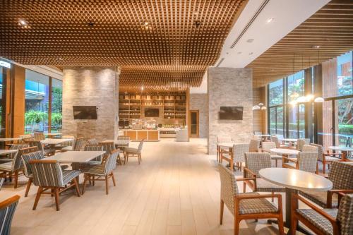 a restaurant with tables and chairs and a kitchen at Holiday Inn Express Phuket Patong Beach Central by IHG in Patong Beach