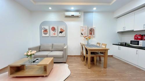 een woonkamer met een bank en een tafel bij DT Happy Homes - Luxury Apartment in Vinhomes Times City in Hanoi