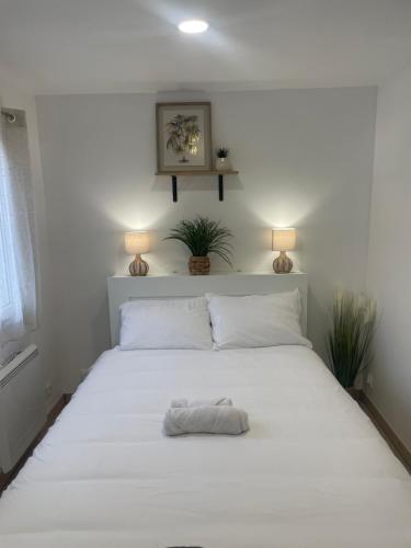 uma cama branca com uma toalha branca em Résidence Chene em Viry-Châtillon