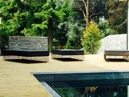 two benches sitting on a wooden deck with trees at Casa Sull'Albero in Malgrate
