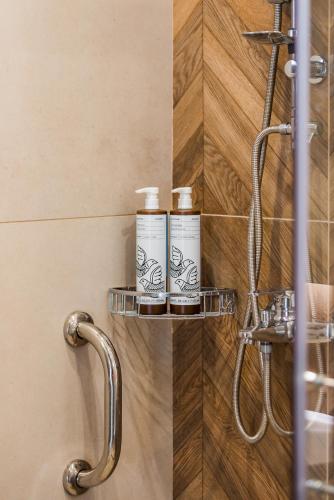 a bathroom with two shampoo bottles on a shelf at Stone & Sea Villas in Nydri