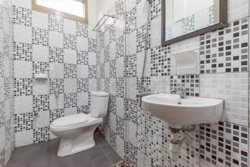 a bathroom with a toilet and a sink at Seruni Guest House Near Alun Alun Lembang Mitra RedDoorz in Lembang