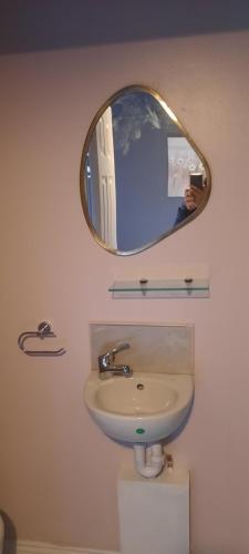 a mirror above a sink in a bathroom at Boutique Guest House in Galway