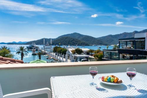 a table with two glasses of wine and a bowl of candy at Dedeminn Garden House in Göcek