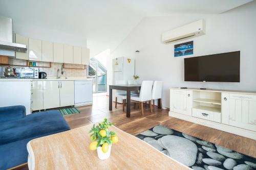 a kitchen and living room with a table and a tv at Dedeminn Garden House in Göcek