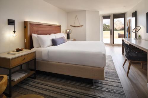 ein Hotelzimmer mit einem großen Bett und einem Schreibtisch in der Unterkunft Sky Rock Sedona, a Tribute Portfolio Hotel in Sedona