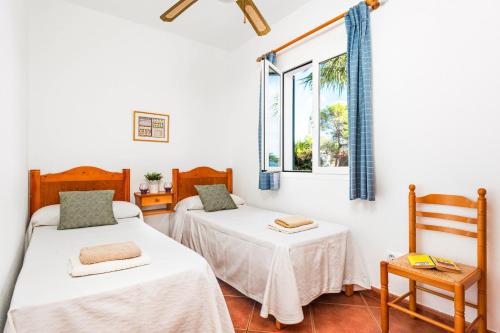 Duas camas num quarto com uma janela em Villa Toymi by Villa Plus em Cala Blanca
