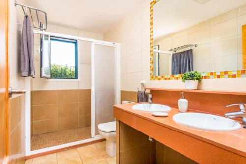 a bathroom with two sinks and a shower at Villa Mediterraneum by Villa Plus in Cala en Forcat