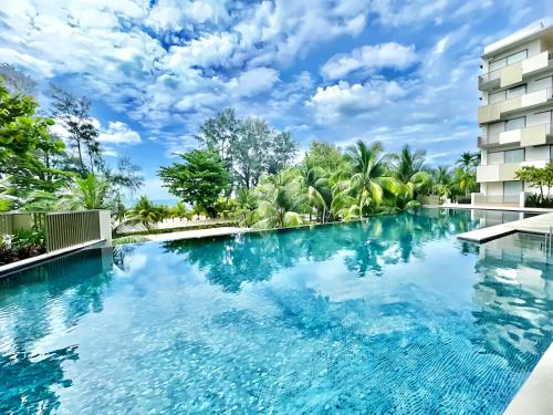 峇都丁宜的住宿－By The Sea Penang，蓝色水面建筑前的游泳池