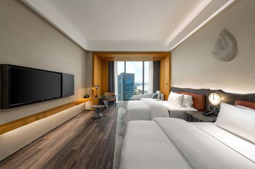 a hotel room with two beds and a flat screen tv at The Westin Yantai in Yantai