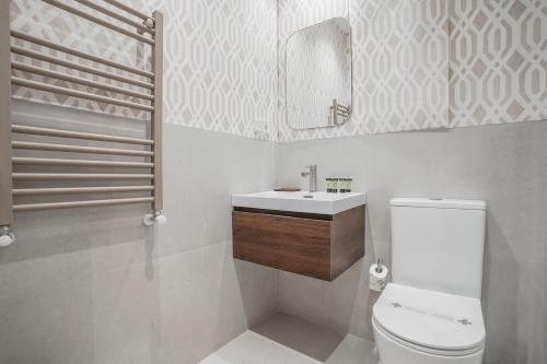 W łazience znajduje się toaleta, umywalka i lustro. w obiekcie Amazing apartment-3Bedrooms 3Bathrooms-Lavapiés w Madrycie