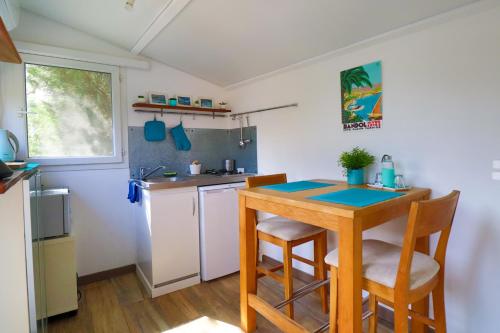 une cuisine avec une table, des chaises et un évier dans l'établissement Le Mas de Bertagne studio kitchenette terrasse piscine, à Gémenos