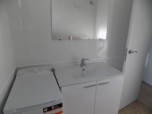a white bathroom with a sink and a mirror at Bon Repos 2 in Torroella de Montgrí
