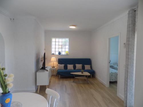 a living room with a blue couch and a table at Bon Repos 2 in Torroella de Montgrí