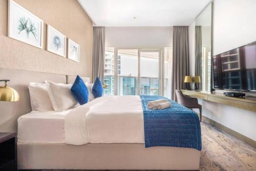 um quarto com uma grande cama branca com toques azuis em Studio Apartment in DAMAC Maison Prive Business Bay - High Floor em Dubai