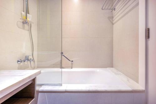 uma casa de banho branca com um chuveiro e uma banheira em Studio Apartment in DAMAC Maison Prive Business Bay - High Floor em Dubai