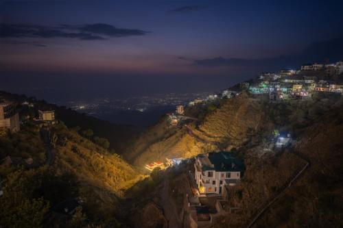 a town on a hill at night at Sunset Vibes! By Western Stays Near Mall Road Kasauli in Kasauli