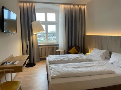 a hotel room with two beds and a window at Flair Hotel zum Schiff in Meersburg