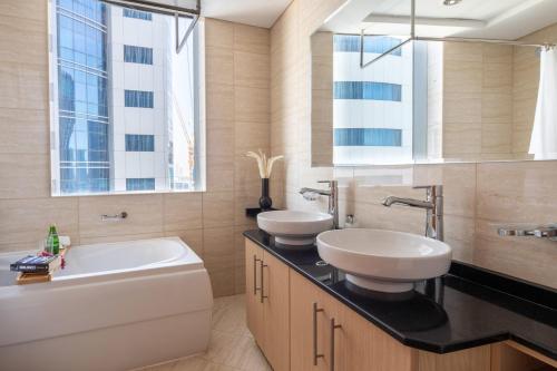 a bathroom with two sinks and a bath tub at Frank Porter - Ocean Heights in Dubai