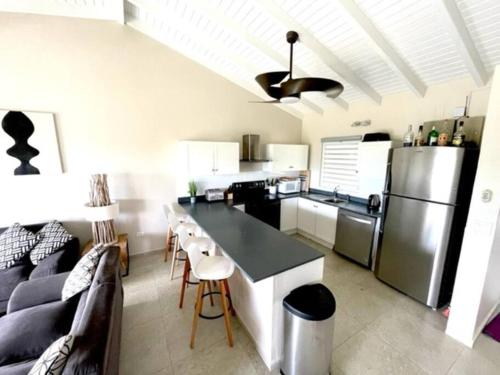 a kitchen and living room with a couch and a refrigerator at New* Tropical Modern Townhouse in SXM in Simpson Bay